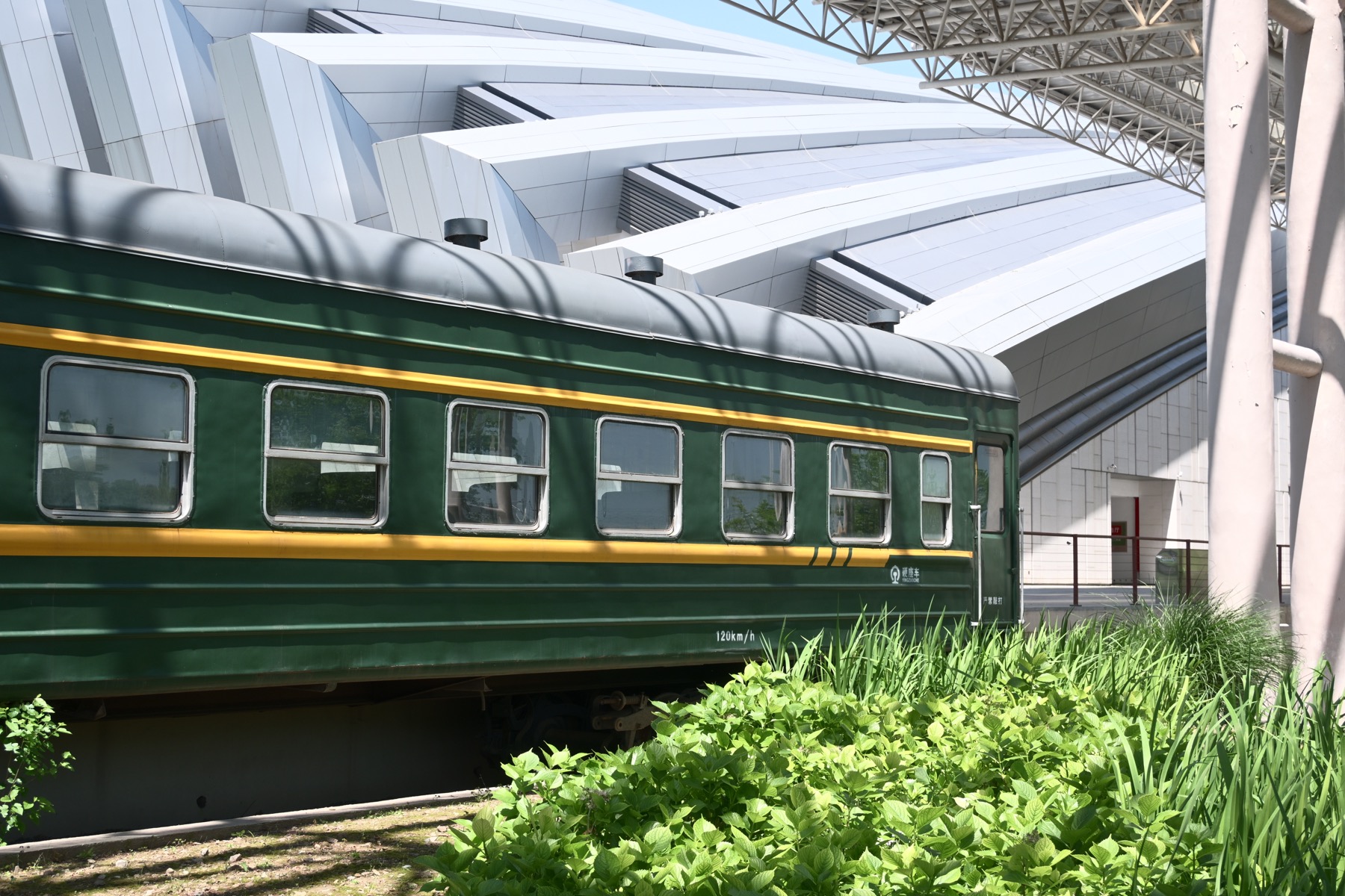 Green train beside a modern station building
